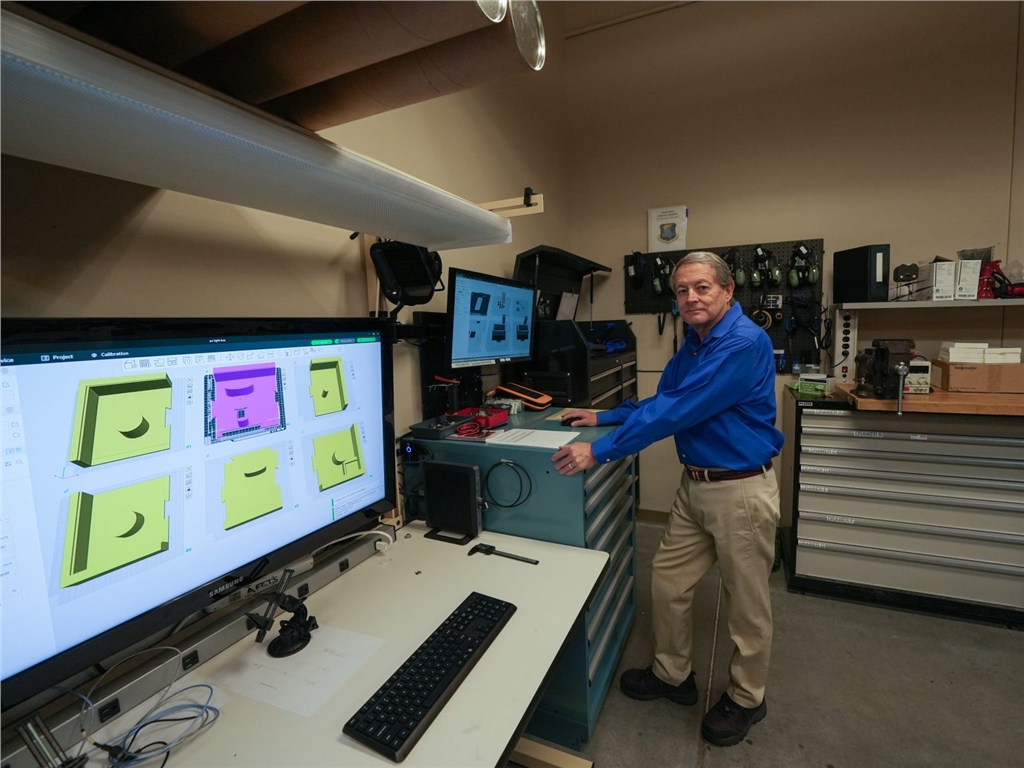 肯農·尼科爾斯（Kennon Nichols）在用於培訓MQ-9飛機維護人員的3D建模作品旁拍照